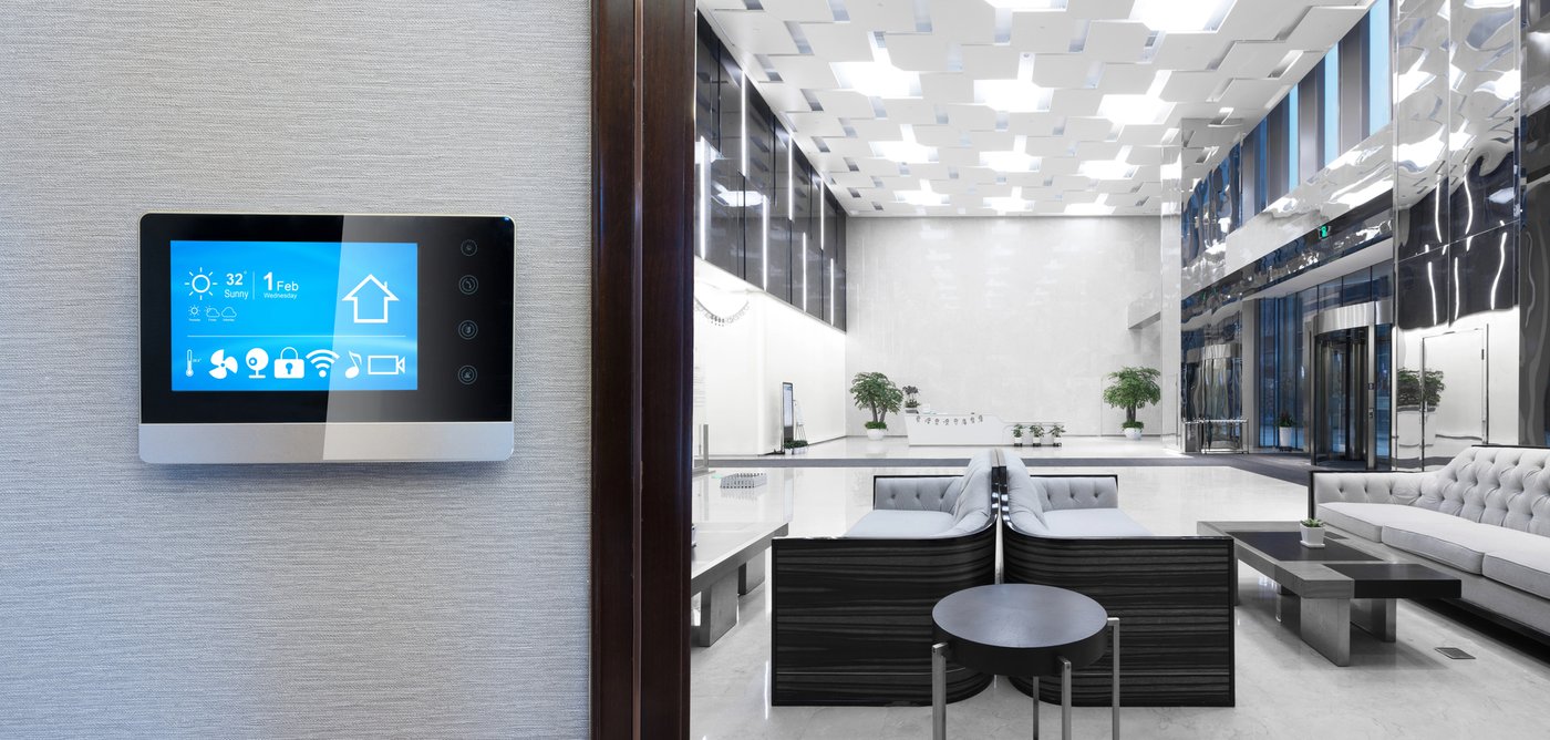 Modern commercial building lobby with wall-mounted smart building automation panel