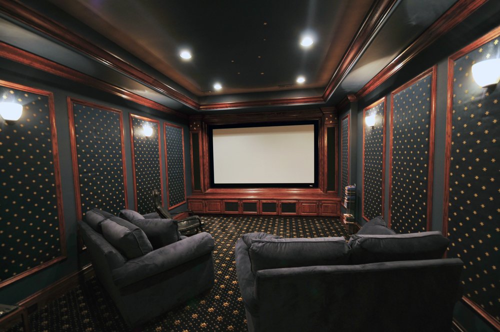 Traditional home theater room with projection screen and theater-style seating