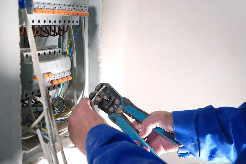 Professional electrician working on electrical panel installation
