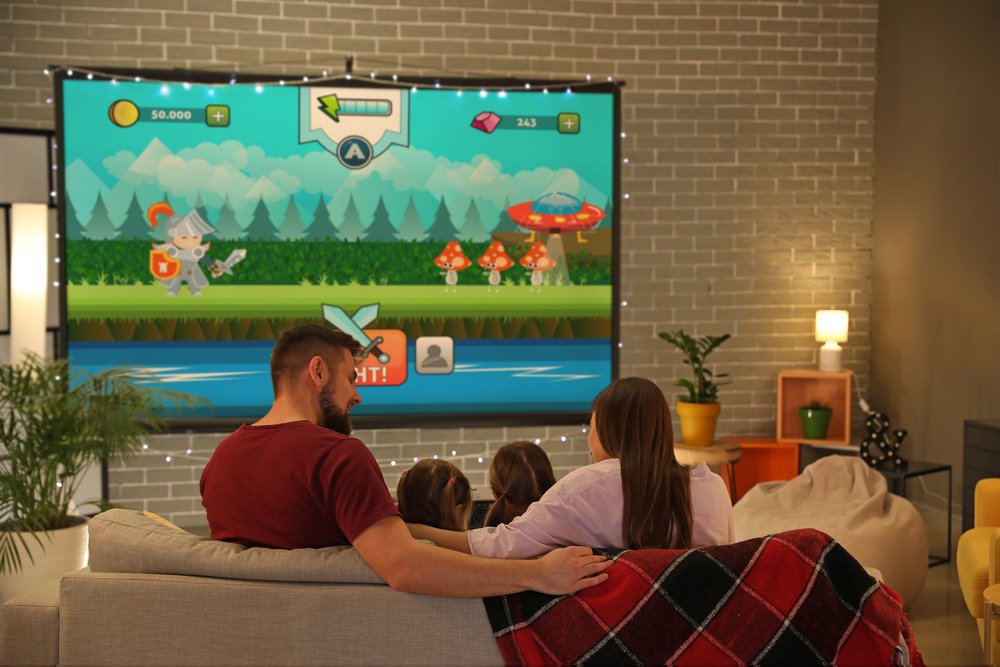 Family watching video game on projector screen in living room