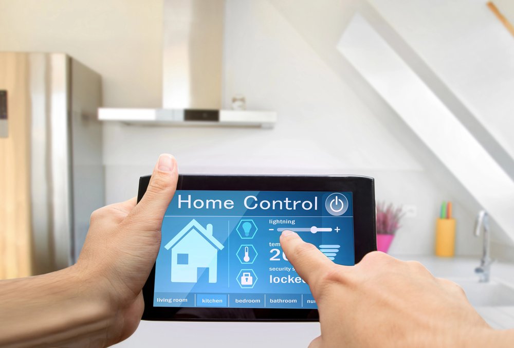Hands holding tablet with home control app in modern kitchen
