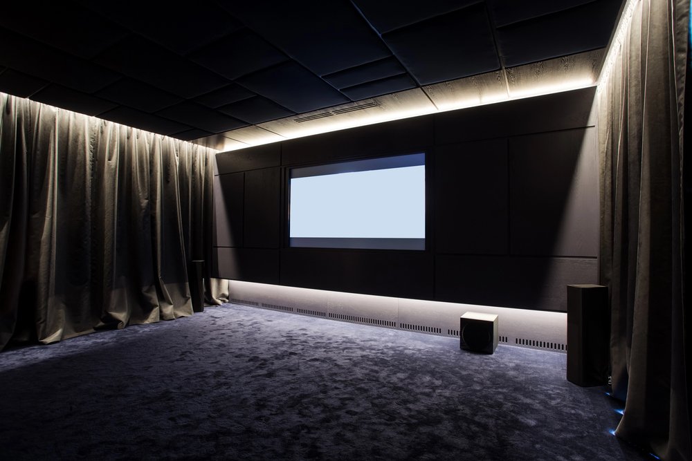 Modern home theater with acoustic curtains and large projection screen