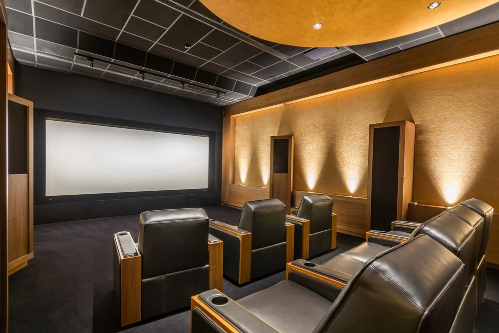 Luxury home theater with leather recliners and warm wood paneling